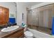 Bathroom with tile shower, single sink, and a wood door at 4825 S Ammons St # 113, Littleton, CO 80123
