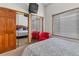 Bedroom with sliding mirror closet doors and a vibrant red chair at 4825 S Ammons St # 113, Littleton, CO 80123