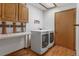 A well-equipped laundry room with washer, dryer, and overhead cabinets for storage at 4825 S Ammons St # 113, Littleton, CO 80123