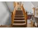 Carpeted staircase with wooden banister leading to the upper level of the home at 4825 S Ammons St # 113, Littleton, CO 80123