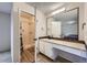 Bathroom featuring a vanity, large mirror, and shower with a white tile surround at 17148 E Evans Dr, Aurora, CO 80013