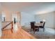 Hallway with wooden floors adjacent to a dining room with gray carpet at 17148 E Evans Dr, Aurora, CO 80013
