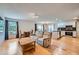 Sun-filled living room featuring hardwood floors seamlessly flowing into the adjacent dining and kitchen areas at 17148 E Evans Dr, Aurora, CO 80013