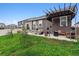 Well-manicured backyard with patio, pergola, grill, dining and lush green clover lawn at 7227 Clarke Dr, Frederick, CO 80530