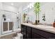 Bathroom featuring double sink vanity, decorative mirror, and glass-enclosed shower at 7227 Clarke Dr, Frederick, CO 80530