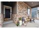 Inviting covered porch adorned with stone accents and decorated with charming rustic elements at 7227 Clarke Dr, Frederick, CO 80530