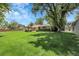 Lush backyard featuring a well-maintained lawn, mature trees, a swing, and patio seating for outdoor enjoyment at 1091 E Pinewood Ave, Centennial, CO 80121