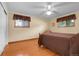 Comfortable bedroom with hardwood floors, ceiling fan, and two windows providing natural light at 1091 E Pinewood Ave, Centennial, CO 80121