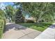 Side exterior home view exhibiting a driveway and mature trees at 1091 E Pinewood Ave, Centennial, CO 80121
