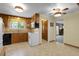Traditional kitchen features wood cabinets, white appliances, and a window over the sink at 1091 E Pinewood Ave, Centennial, CO 80121