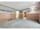 Neutral living room with carpet, wood wall paneling, and access to kitchen at 1091 E Pinewood Ave, Centennial, CO 80121