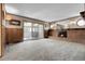 Cozy living room with a brick fireplace, vintage sconces, and sliding doors to the sunroom at 1091 E Pinewood Ave, Centennial, CO 80121