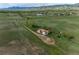 Sprawling aerial view of property surrounded by beautiful green land and mountains at 8602 N 39Th St, Longmont, CO 80503