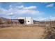 Exterior of a metal barn with a dirt area in front and rolling hills in the distance at 8602 N 39Th St, Longmont, CO 80503