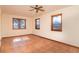 Sunlit bedroom with Saltillo tile floor, ceiling fan, and three windows showcasing scenic views at 8602 N 39Th St, Longmont, CO 80503