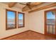 Bright bedroom features Saltillo tile, ceiling fan, and two windows showcasing scenic views at 8602 N 39Th St, Longmont, CO 80503