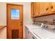 Convenient laundry room area with wooden cabinets, utility sink, and modern washer and dryer at 8602 N 39Th St, Longmont, CO 80503