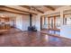 Open-concept living area with wood-burning stove, tile floors, wood beams and kitchen view at 8602 N 39Th St, Longmont, CO 80503