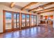 Spacious living room featuring tile floors, wood beam ceiling, and multiple doors leading to patio at 8602 N 39Th St, Longmont, CO 80503