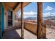 Covered patio featuring rustic wooden pillars with mountain views beyond the yard at 8602 N 39Th St, Longmont, CO 80503