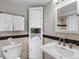Bathroom with neutral walls, black and tan tile accent, white cabinetry and towel racks at 2047 S Milwaukee St # 4, Denver, CO 80210