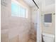 Tiled shower with a window, white shower curtain, and neutral paint creating a serene bathing space at 2047 S Milwaukee St # 4, Denver, CO 80210