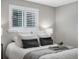 Bright bedroom featuring white bedding, throw blanket, a window with shutters, and gray walls at 2047 S Milwaukee St # 4, Denver, CO 80210