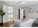 Comfortable bedroom features white bedding, a ceiling fan, an adjacent bathroom, and wood floors at 2047 S Milwaukee St # 4, Denver, CO 80210
