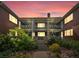 Exterior of the apartment with balconies, garden, and brickwork under a colorful sunset sky at 2047 S Milwaukee St # 4, Denver, CO 80210
