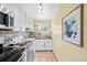 Well-appointed kitchen features stainless steel appliances, white cabinetry and stone tile flooring at 2047 S Milwaukee St # 4, Denver, CO 80210