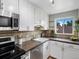 Bright kitchen featuring white cabinets, stainless steel appliances, earth tone countertops, and tile backsplash at 2047 S Milwaukee St # 4, Denver, CO 80210