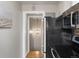 Galley style kitchen features stainless steel appliances and view into hall with pendant light at 2047 S Milwaukee St # 4, Denver, CO 80210