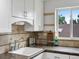 Bright kitchen featuring white cabinets, earth tone countertops, tile backsplash, and kitchenware at 2047 S Milwaukee St # 4, Denver, CO 80210