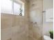 Shower featuring neutral-toned tile, dual showerheads, and a window shelf with decorative greenery at 2047 S Milwaukee St # 4, Denver, CO 80210