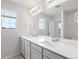 Bright bathroom featuring a double sink vanity, large mirror, and a window at 8819 Sedalia St, Commerce City, CO 80022