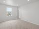 Bright, carpeted bedroom with large window, door, and recessed lighting; neutral color scheme at 8819 Sedalia St, Commerce City, CO 80022