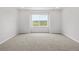 Spacious bedroom features neutral carpet, recessed lighting, and a window with a view of the outside at 8819 Sedalia St, Commerce City, CO 80022