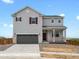 Two-story home featuring a gray exterior, brick accents, and a two-car garage at 8819 Sedalia St, Commerce City, CO 80022