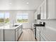 Bright kitchen features a center island, stainless steel appliances, and sliding door to outside at 8819 Sedalia St, Commerce City, CO 80022