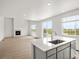Bright open-concept space with center island and gas fireplace at 8819 Sedalia St, Commerce City, CO 80022