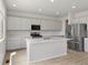 Bright kitchen with modern appliances, center island, and light gray cabinets at 8819 Sedalia St, Commerce City, CO 80022
