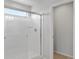 Bright bathroom shower with glass doors and white tiled walls, plus a window for natural light at 8819 Sedalia St, Commerce City, CO 80022