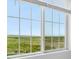 Close-up of a window with a beautiful view of a large, green field under a blue sky at 8819 Sedalia St, Commerce City, CO 80022