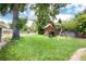 Expansive backyard featuring a play set, mature trees, and a well-maintained lawn at 585 Estes St, Lakewood, CO 80226