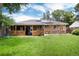 View of the backyard with solar panels, covered patio, and lush green grass, perfect for outdoor enjoyment at 585 Estes St, Lakewood, CO 80226