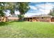 Lush backyard featuring a patio area, play set, and ample green space for outdoor activities at 585 Estes St, Lakewood, CO 80226