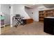 Finished basement area with neutral carpet, a wooden hutch, keyboard and bench near a doorway at 585 Estes St, Lakewood, CO 80226