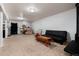 Unfinished basement with carpet, workout equipment, a black futon, and a colorful rocking chair at 585 Estes St, Lakewood, CO 80226