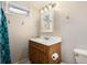 Bathroom with wooden vanity, modern faucet, medicine cabinet, and unique lighting fixture at 585 Estes St, Lakewood, CO 80226