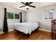 Bright bedroom boasts hardwood floors, a ceiling fan, and a large window with natural light at 585 Estes St, Lakewood, CO 80226